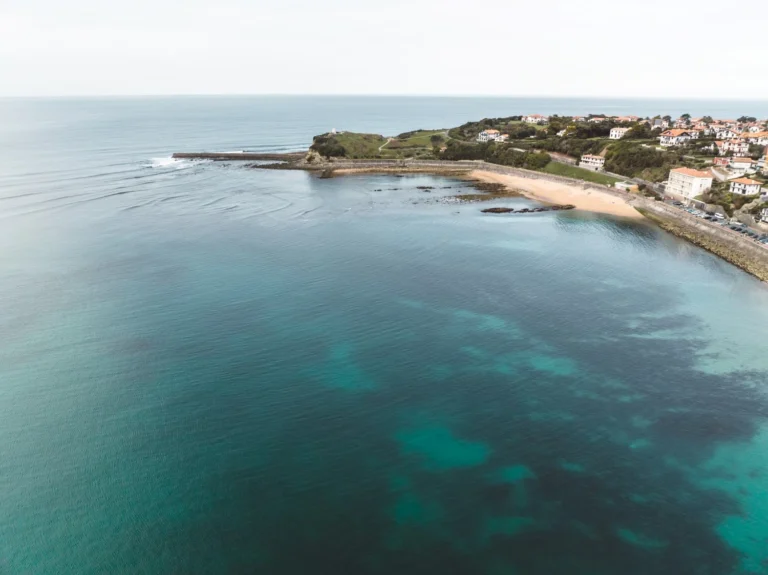 Une personne pratiquant la marche aquatique sur une plage paradisiaque, illustrant une destination idéale pour le longe-côte.
